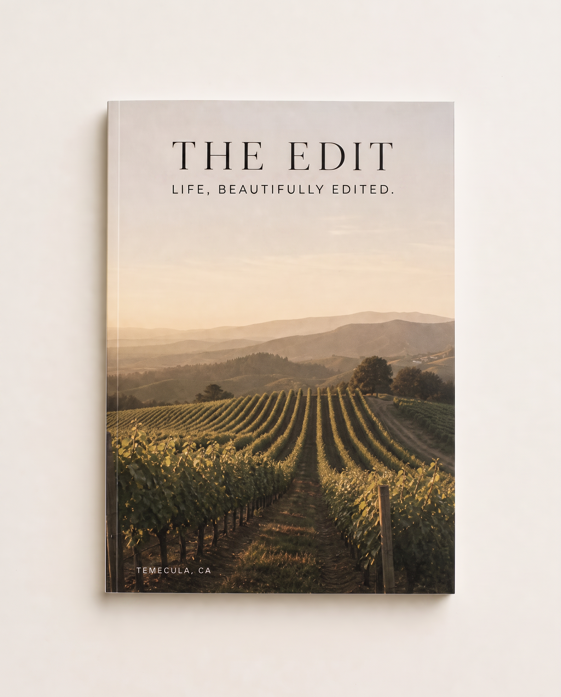Volume One of THE EDIT lying flat on a pale ivory surface, its vineyard cover filling the frame